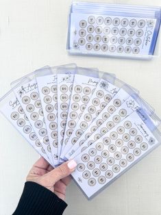 a person is holding up several stickers with numbers on them, and the other one has