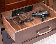 the drawer is open to show an electronic device and charger on it's side