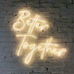 a brick wall with a neon sign that says better together on it and the words below it