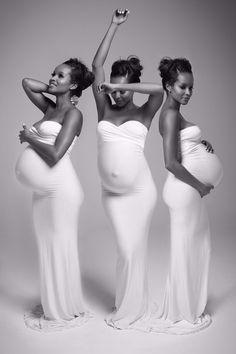 three pregnant women in white dresses posing for the camera with their hands on their hips