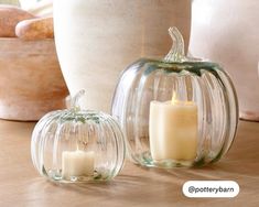 two glass pumpkins sitting on top of a wooden table