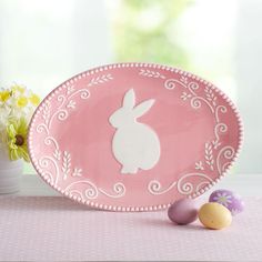 a pink plate with an easter bunny cut out on the side next to some eggs