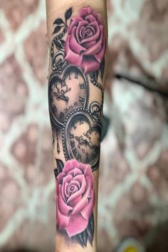 a woman's arm with pink roses and heart shaped clocks on the inside of it