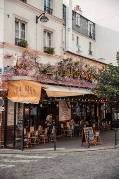 the outside of a restaurant with tables and chairs on the sidewalk in front of it