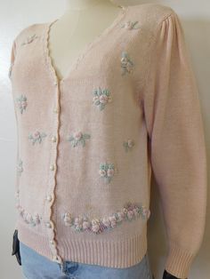 A pretty pale pink 90's vintage cottagecore style cardigan- by Worthington- scalloped neckline- closes w/ faux pearl & gold-toned buttons- 3d rose buds- shoulder pleats- elastic band cuffs and waistMATERIAL:- 55% ramie 45% cottonSIZE: marked L, ideal as a medium-large (as reference"model" is 6' w/ 34" bust 25" waist 38" hips)40" bust22" shoulder to hemCONDITION:- great vintage condition- there is a small faint yellow (untreated) spot on the front bottom of the sweater, not a big deal____________________________Please ask any questions, I'm here to help!Thank you for shopping at Madness For Vintage 90s Cardigan, Vintage Pink Sweater For Fall, Vintage Pink Crew Neck Tops, Pink Vintage Spring Sweater, Pink Vintage Winter Cardigan, Pink Vintage, Pink Cottagecore, Vintage Pink Cardigan With Buttons, Cottagecore Sweater