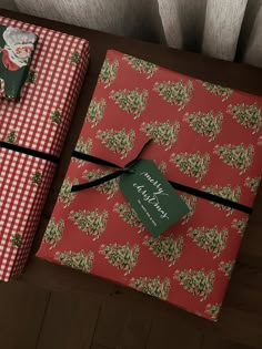 two wrapped presents sitting on top of a wooden table