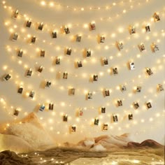 there are many pictures hanging on the string lights in this room, and it looks like they have been decorated with fairy lights