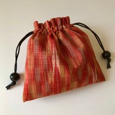 "- handmade from Japanese vintage kimono ikat Kasuri wool fabric - perfectly sized so that you can carry your small essentials, such as makeup, cell phone, etc. - pouch measures approximately 7\" x 6.5\" when open - drawstring is a rat tail cord trimmed with black wooden beads (I am currently out of the white beads) - lined with a gray cotton chambray fabric - each pouch is made to order so no two will look alike - the fabric placements will be slightly different If you would like a pouch made i Gift Woven Pouch, Traditional Red Pouch For Everyday Use, Wool Kimono, Making Bags, Rat Tail, Kimono Vintage, Rice Bags, A Rat, Chambray Fabric