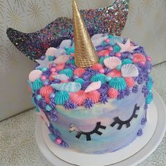 there is a cake decorated with unicorns and seashells