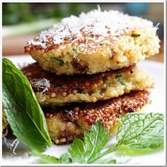 three crab cakes are stacked on top of each other with fresh mint sprigs