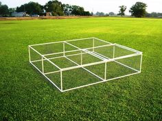 a clear box sitting on top of a lush green field with trees in the background