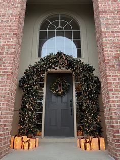 the front door is decorated for christmas with wreaths and lights