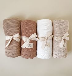 four different types of towels tied together in white, brown and beige colors with bows