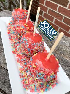 two cake pops covered in sprinkles on a white plate