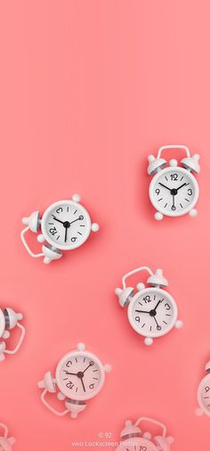 several different clocks on a pink background