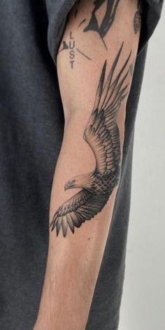 a man's arm with an eagle tattoo on it