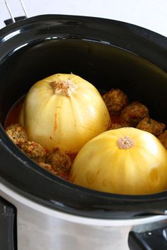 two onions and meatballs are in the slow cooker, ready to be cooked