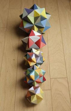 several colorful origami balls are arranged on the floor in order to form a pyramid