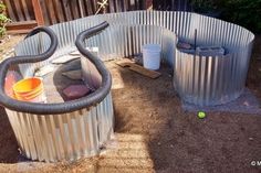 an outdoor bathtub with two buckets and a hose attached to the side of it