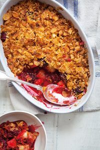 two bowls filled with fruit and crumbled toppings on top of a table