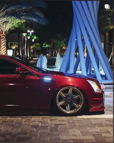 a red car parked in front of a fountain