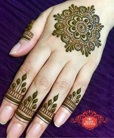 a woman's hand with henna tattoos on it