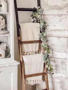 an old ladder is used as a towel rack