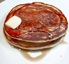 pancakes with butter and syrup on a white plate