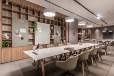 an empty conference room with many chairs and desks in front of the bookshelves