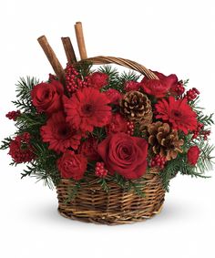 a basket filled with red flowers and pine cones