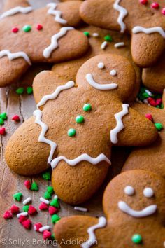 gingerbread cookies with white icing and sprinkles on a wooden surface