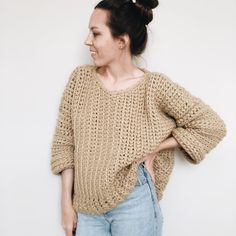 a woman standing in front of a white wall with her hands on her hips