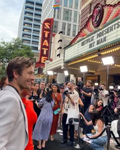 a man standing in front of a movie theater