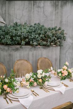 the table is set with flowers and place settings