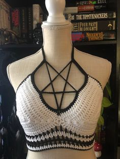 a white mannequin with black and white crochet on it's chest