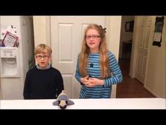 two young children standing in front of a refrigerator with a stuffed animal on the counter