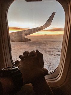 the view from inside an airplane looking out at clouds and planes wing as it flies