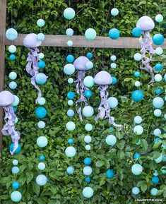 blue and white decorations hanging from a wooden fence