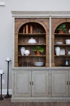 an old china cabinet with potted plants on top