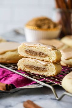 some cookies that are sitting on a cooling rack with cinnamon rolls in front of them