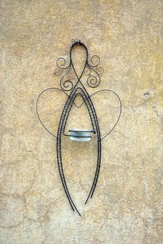 a metal sculpture on the side of a building with an iron design and curved handle