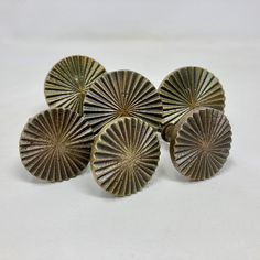 four antique brass knobs on a white background