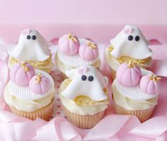 cupcakes with white frosting and pink decorations