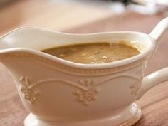 a white gravy dish sitting on top of a wooden table