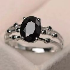 a black diamond ring sitting on top of a white box