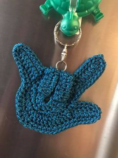 a crocheted keychain with a green turtle on the front and a blue turtle on the back