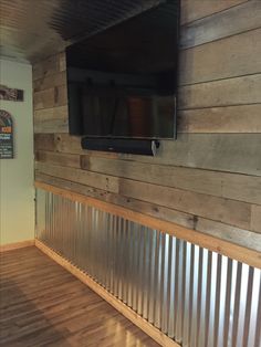 a tv mounted to the side of a wooden wall