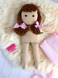 a stuffed doll laying on top of a white rug next to other items and accessories