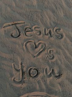 the words jesus loves you written in sand