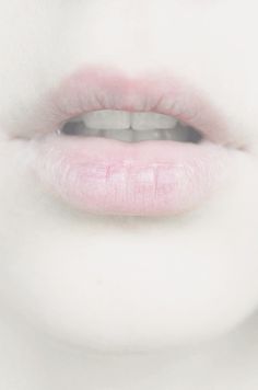 a woman's lips with pink lipstick on the bottom and white skin around her